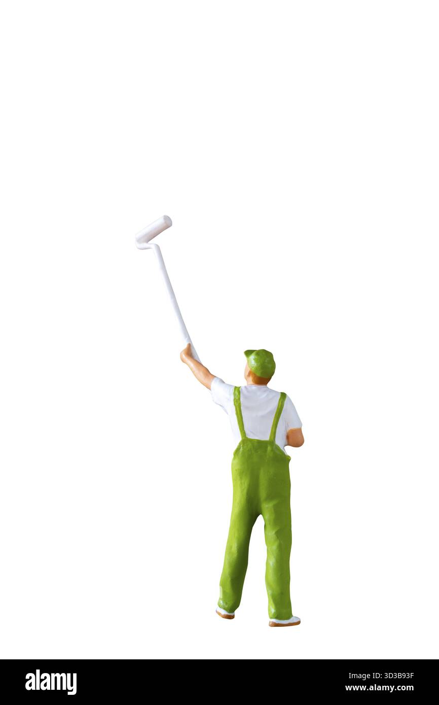 Una statuetta in miniatura di un pittore che indossa tute verdi e tiene in mano una spazzola a rullo con manico lungo, isolata su sfondo bianco con percorso di ritaglio Foto Stock
