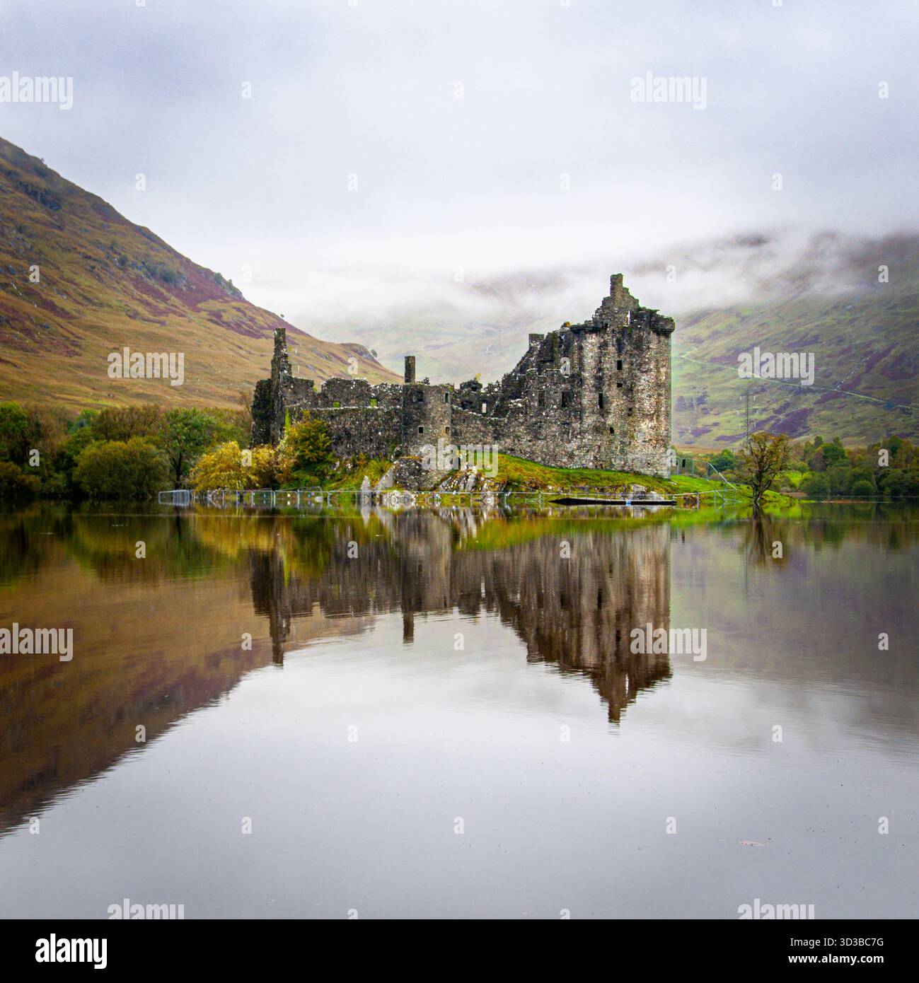 Le rovine del castello di Kilchurn si riflettono nelle acque di Loch Awe sotto un cielo nuvoloso Foto Stock