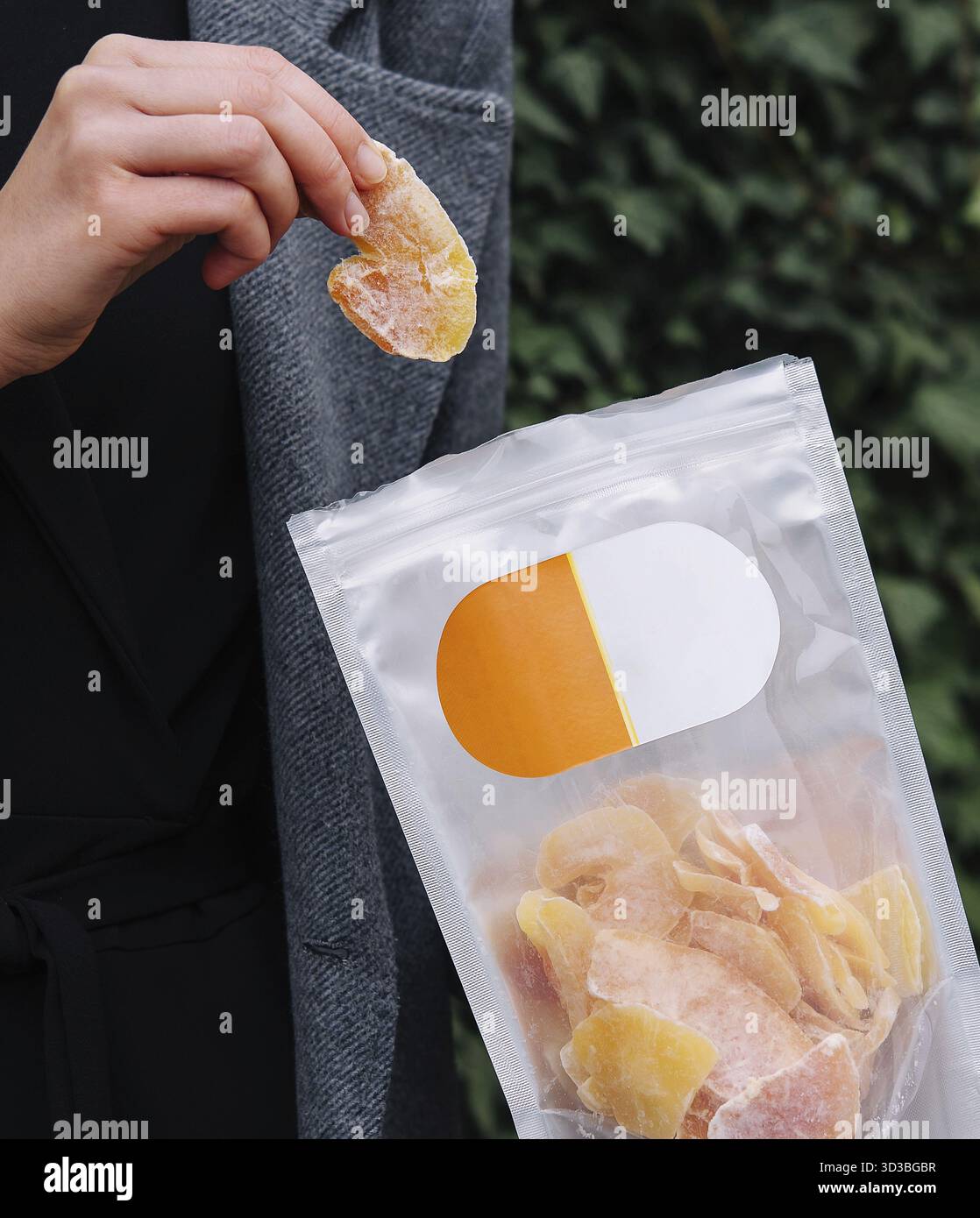 Cibo, ragazza che mangia fette di mango essiccate Foto Stock