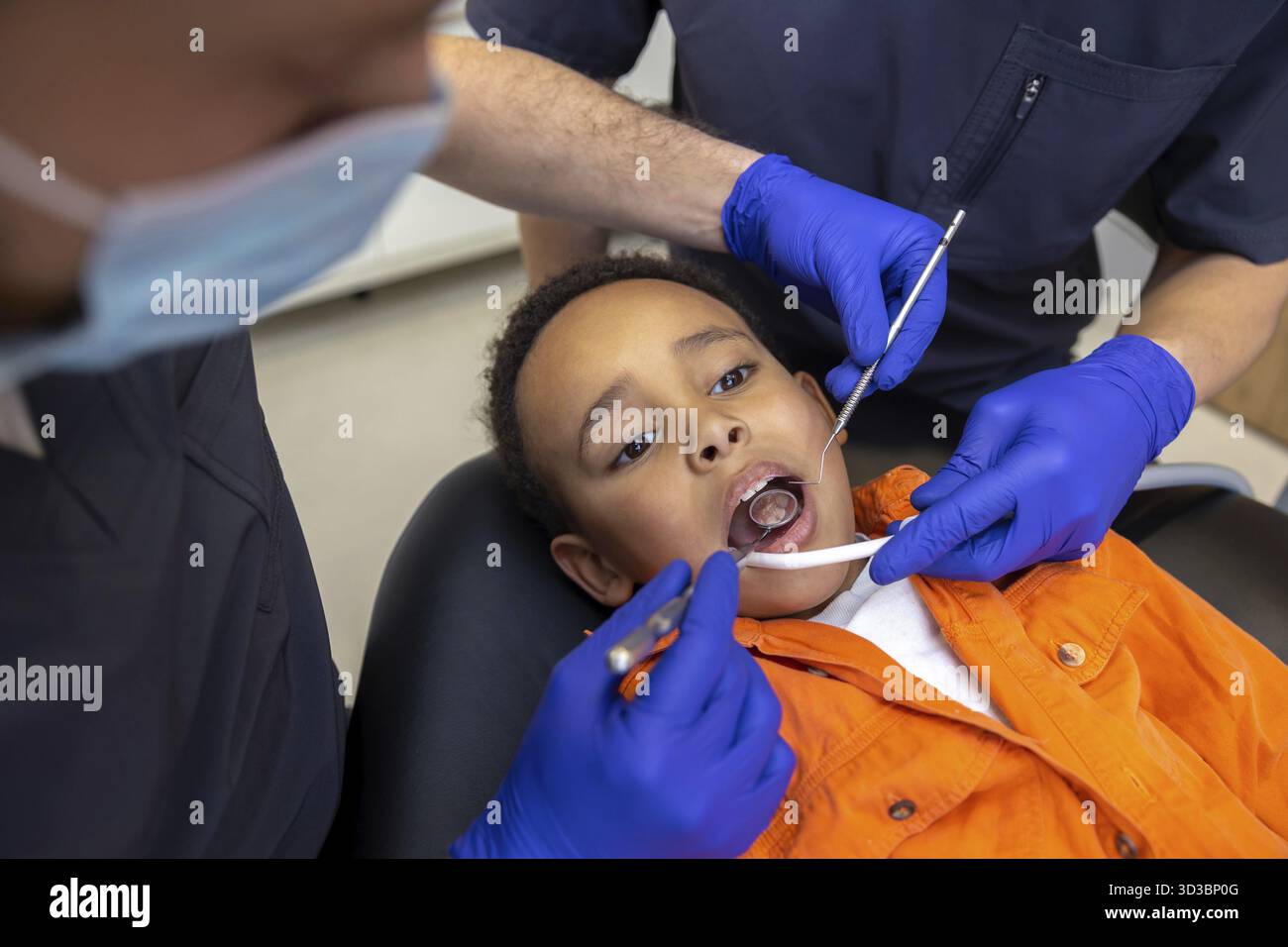 In odontoiatria. Il dentista e il suo assistente curano i denti dei ragazzi Foto Stock