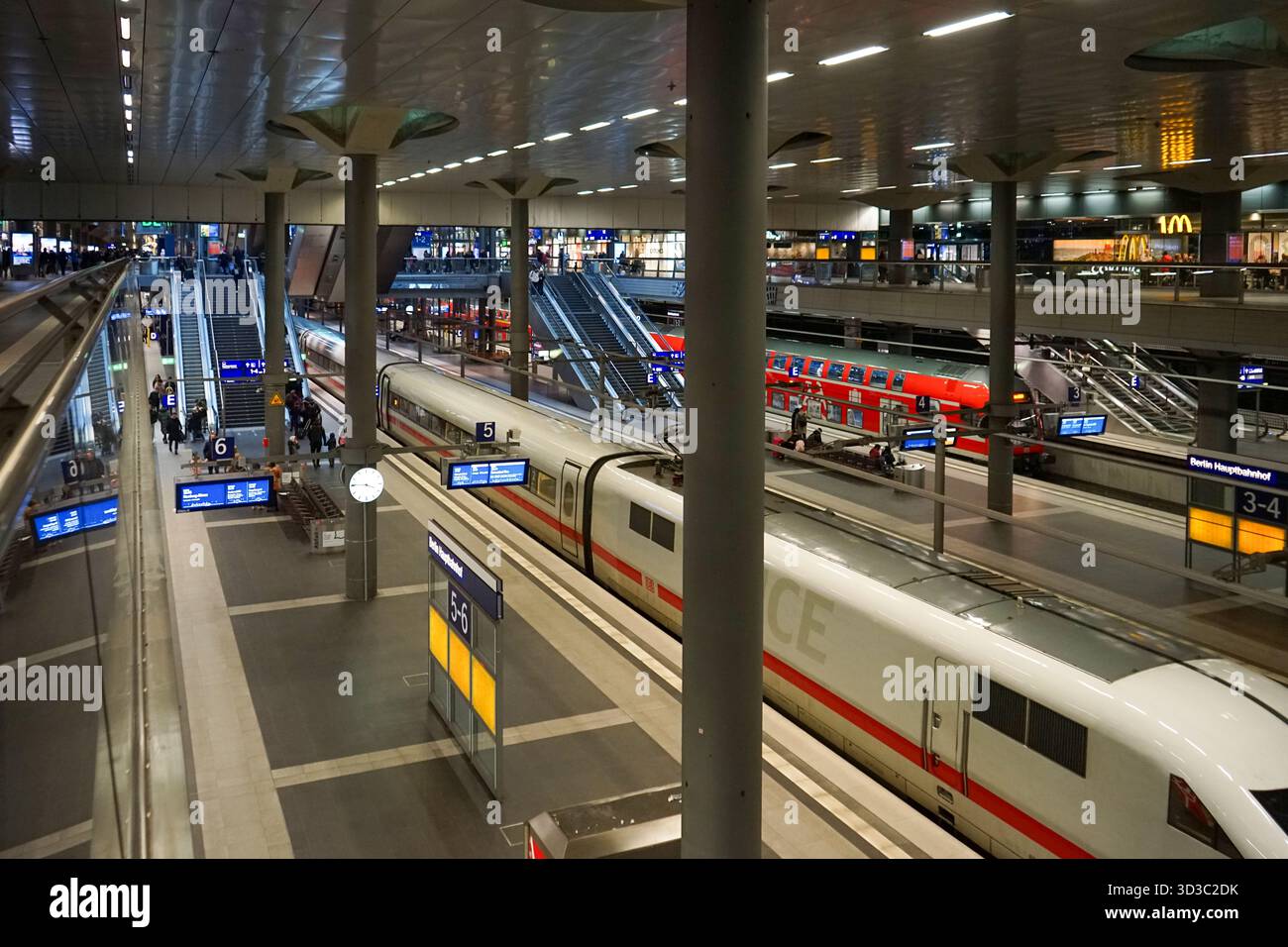 Moderne piattaforme alla stazione centrale di Berlino con treni ICE e regionali sotto le luci DELLA più grande stazione ferroviaria della Germania. Foto Stock