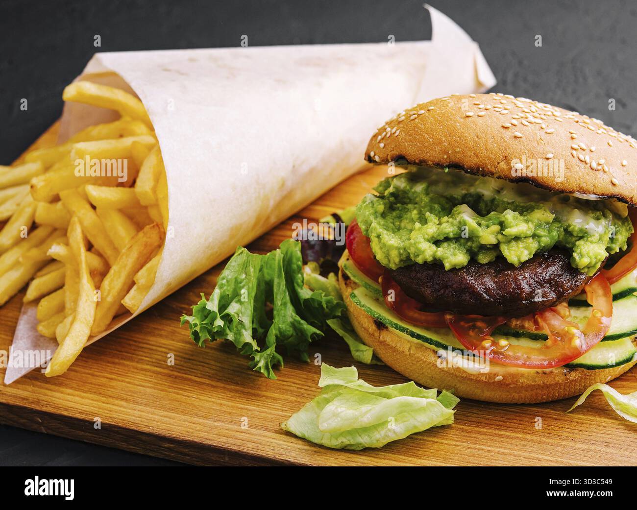 Cibo, hamburger con patatine fritte su vassoio di legno Foto Stock