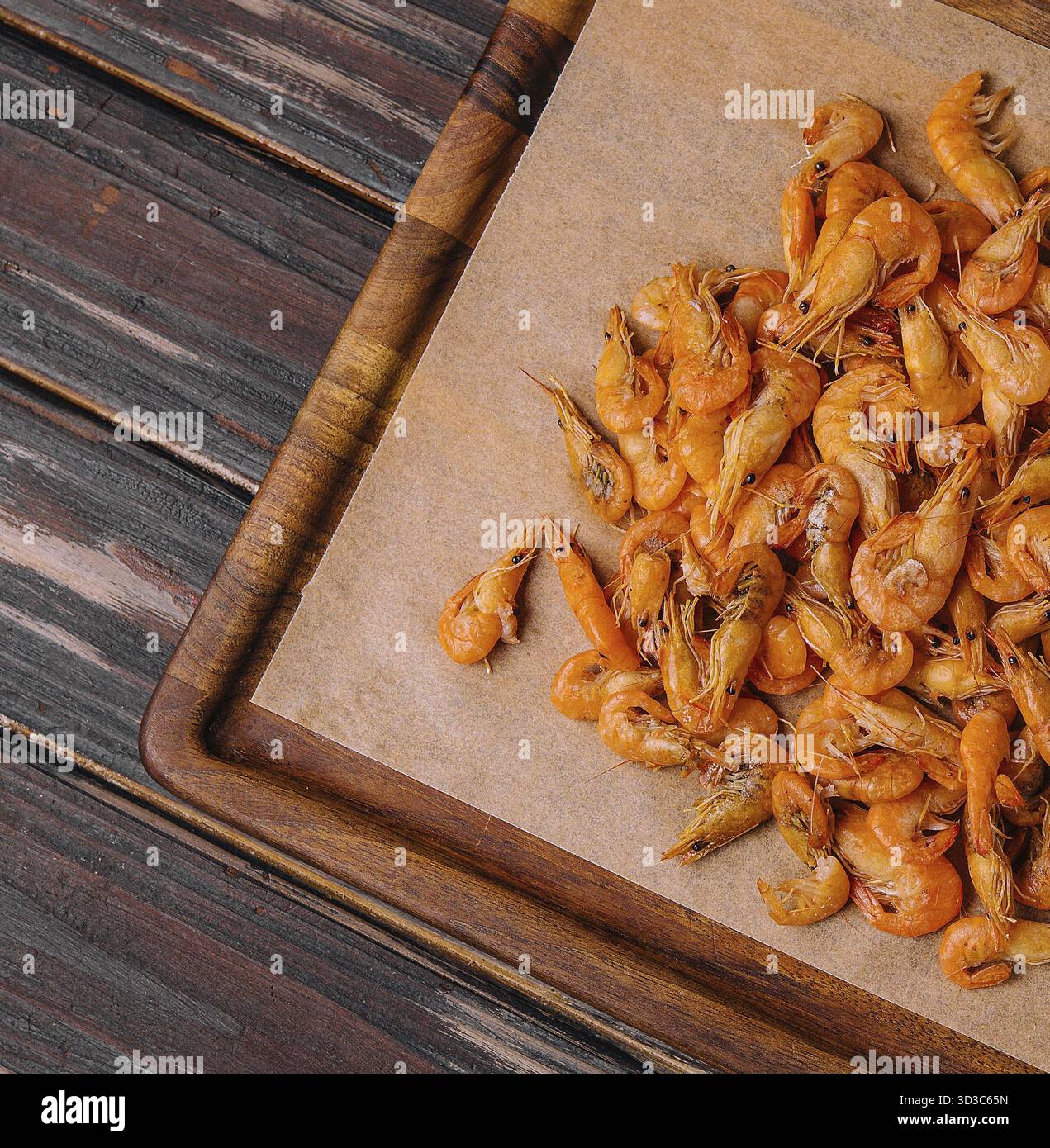 Cibo, piccoli gamberi cotti su vassoio di legno Foto Stock