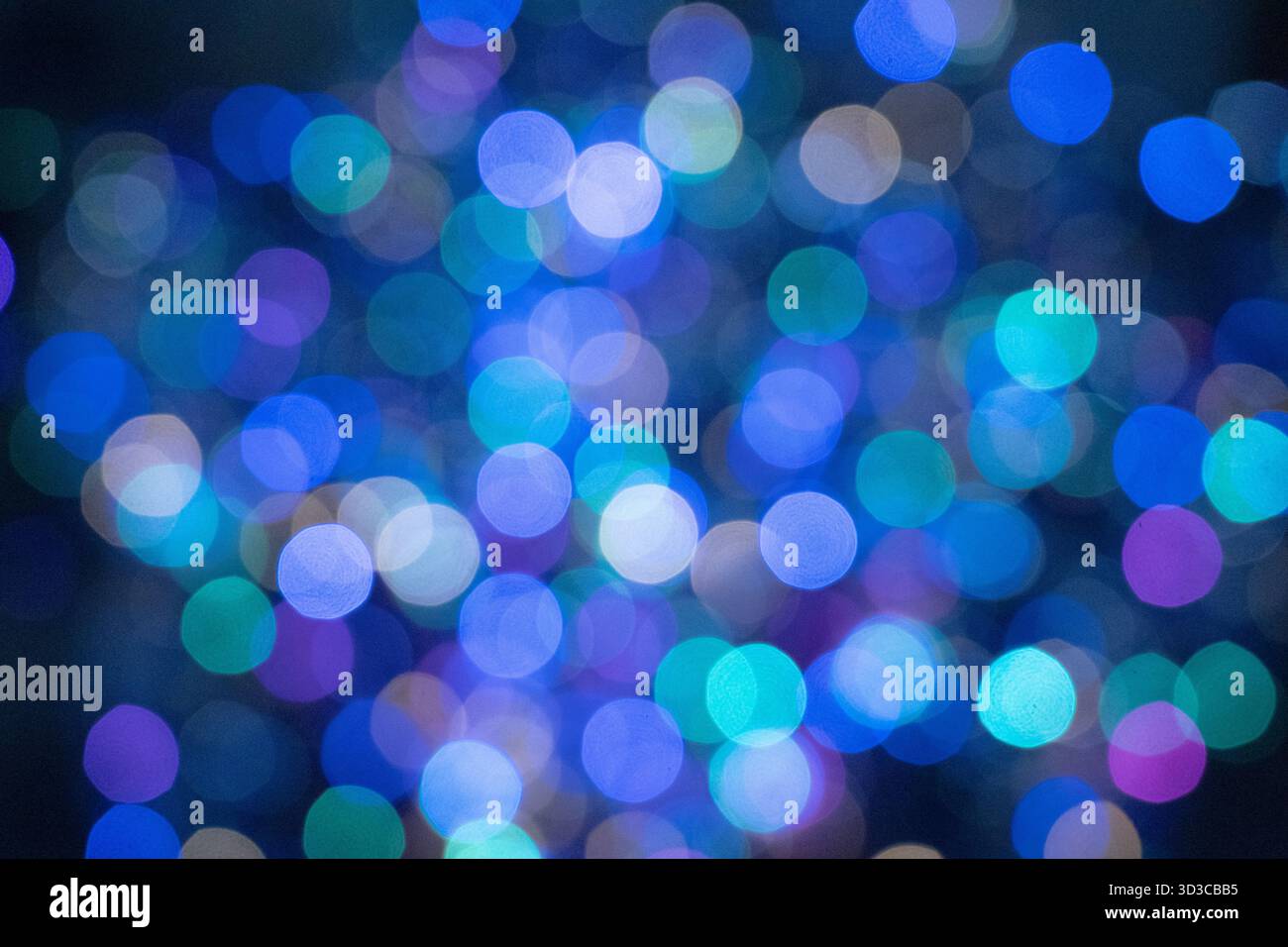 Un'immagine a messa a fuoco morbida che mostra un bellissimo mix di luci bokeh blu, verde acqua e viola, creando uno sfondo onirico e astratto perfetto per le feste, crea Foto Stock