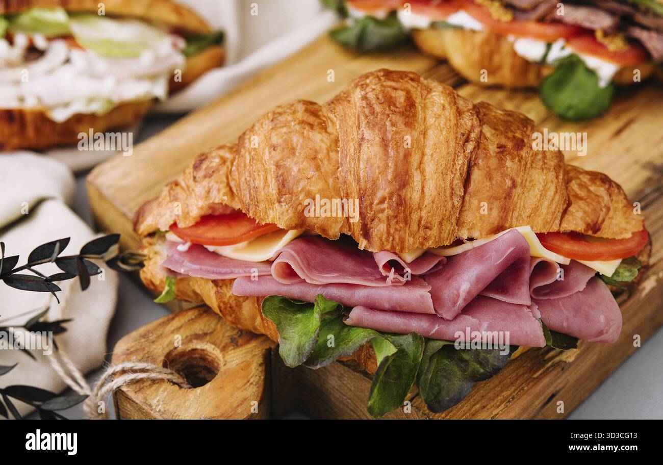 Cibo, delizioso panino con croissant su tavola di legno Foto Stock