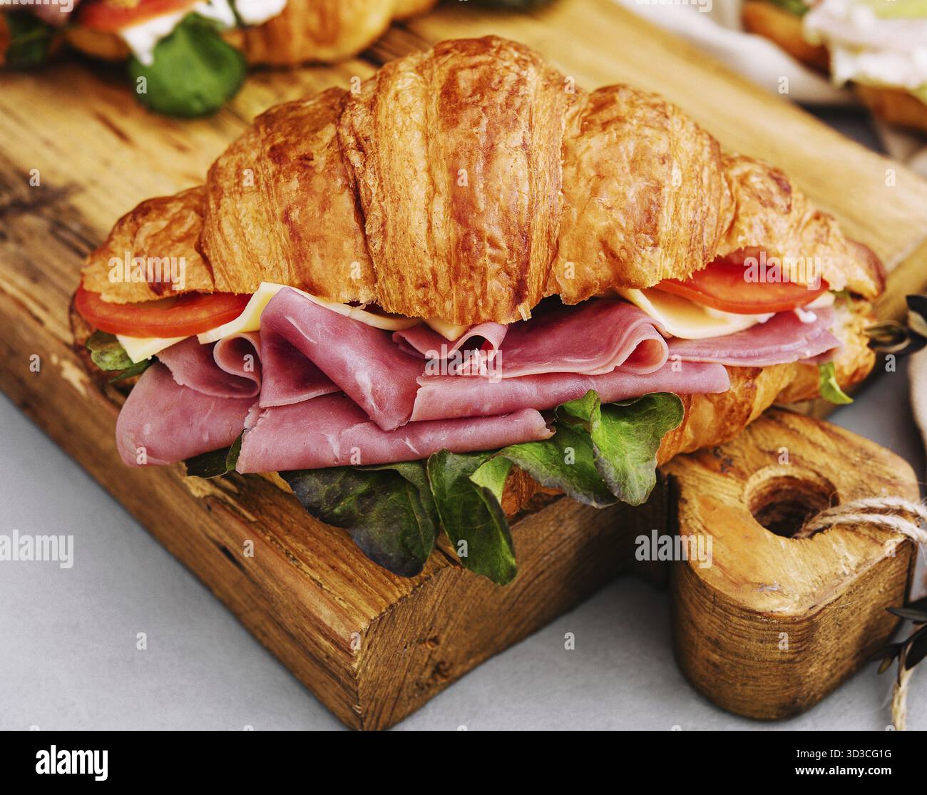 Cibo, delizioso panino con croissant su tavola di legno Foto Stock