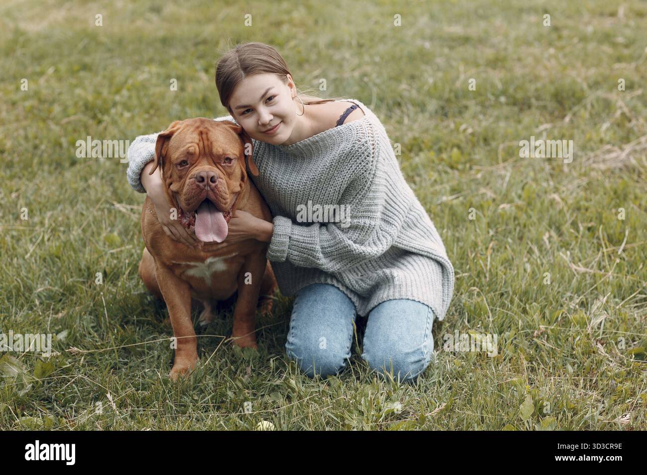 Dogue de Bordeaux o Massiff francese con giovane donna al parco all'aperto Foto Stock