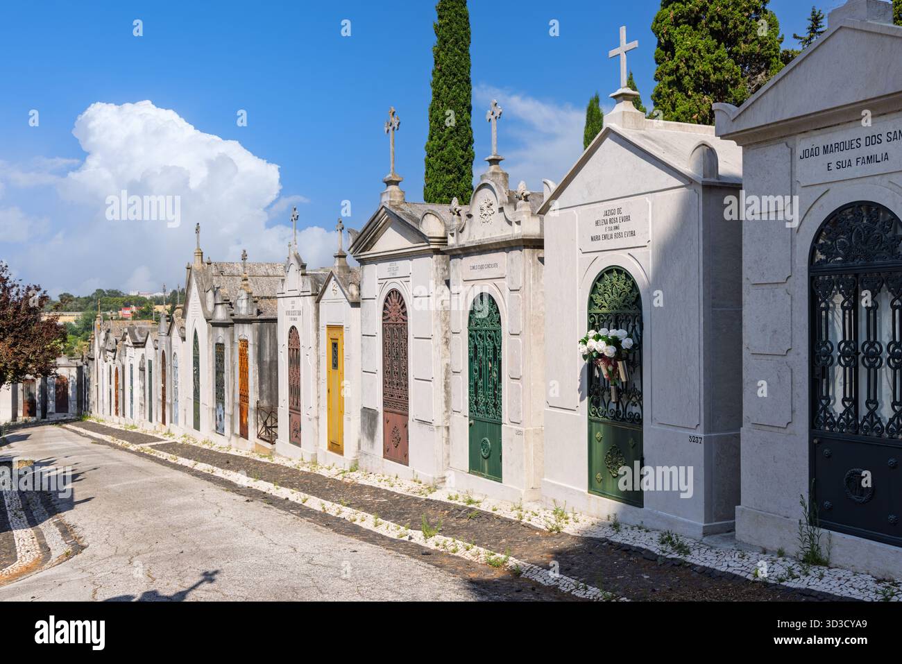 Una suggestiva fila di mausolei ornati al Cimitero Prazeres di Lisbona, ognuno caratterizzato da una porta o un cancello unico e colorato in vari stili. Lisbona, Portogallo Foto Stock