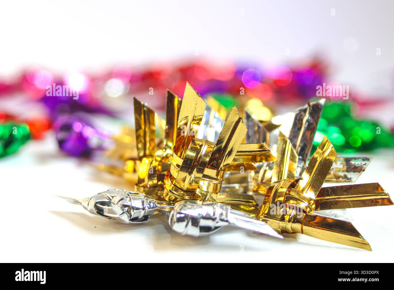 Pesce intrecciato tailandese metallico argento e oro su sfondo bianco con un luminoso bokeh festivo, che unisce artigianato tradizionale e celebrazione moderna. Foto Stock