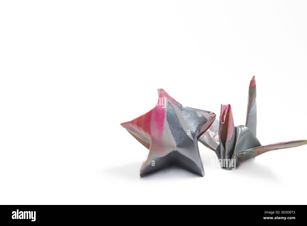 Origami Crane giapponese e Lucky Star su sfondo bianco. Simbolo di speranza e aspirazione. Eccellente spazio di copia per la progettazione. Foto Stock
