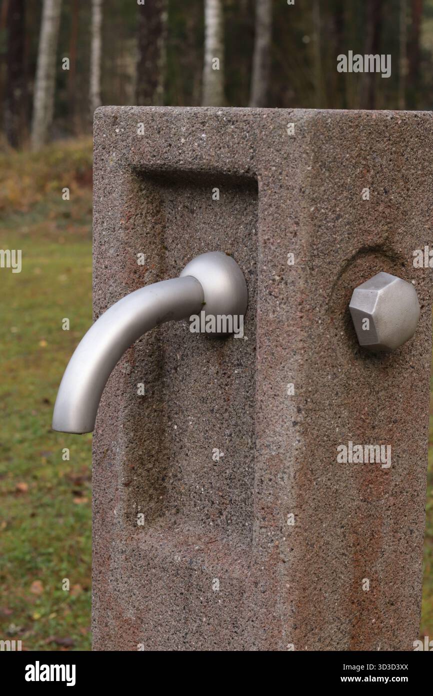 Fontana esterna di acqua potabile in pietra: Design minimalista e infrastrutture pubbliche sostenibili Foto Stock