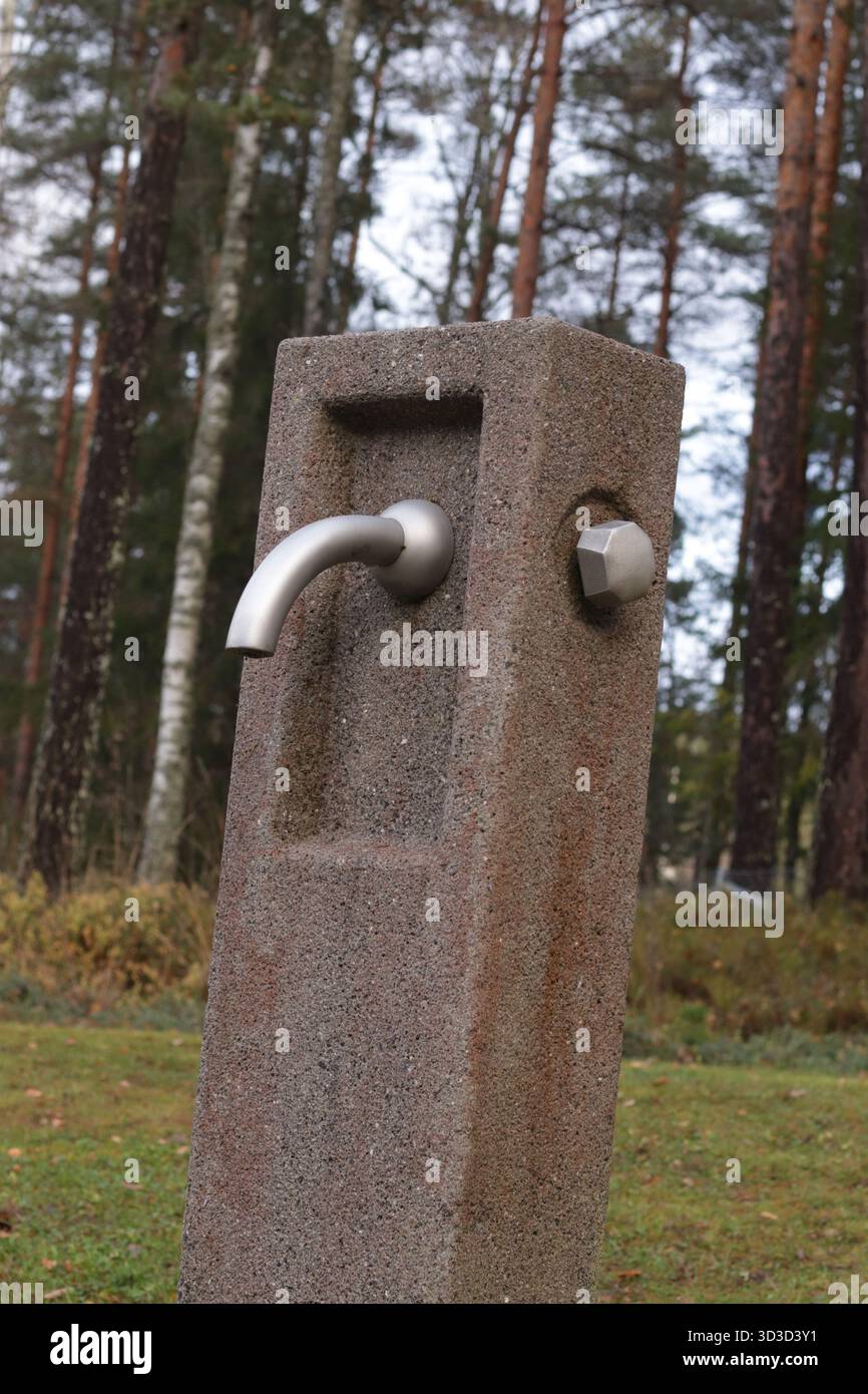 Fontana esterna di acqua potabile in pietra: Design minimalista e infrastrutture pubbliche sostenibili Foto Stock