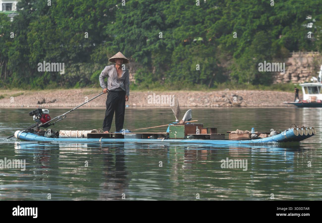 Yangshuo, Cina - Agosto 2019 : uomo sulla piccola barca di bambù che attraversa il fiume li a Yangshuo, provincia di Guangxi Foto Stock