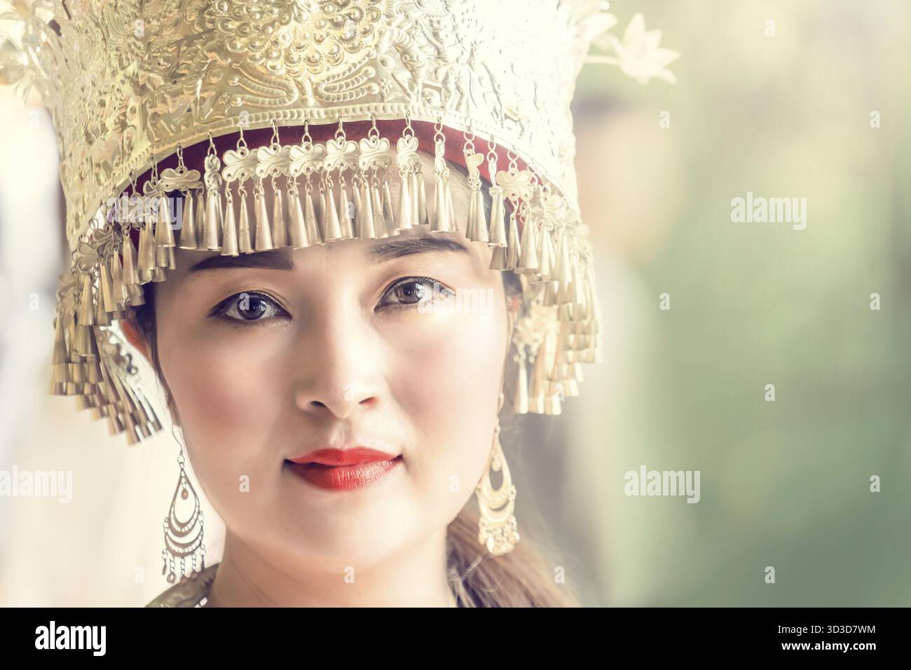 Zhangjiajie, Cina - agosto 2019 : ritratto culturale di una bella donna cinese in un tradizionale abito cinese, con un cappello decorato d'oro e una S Foto Stock