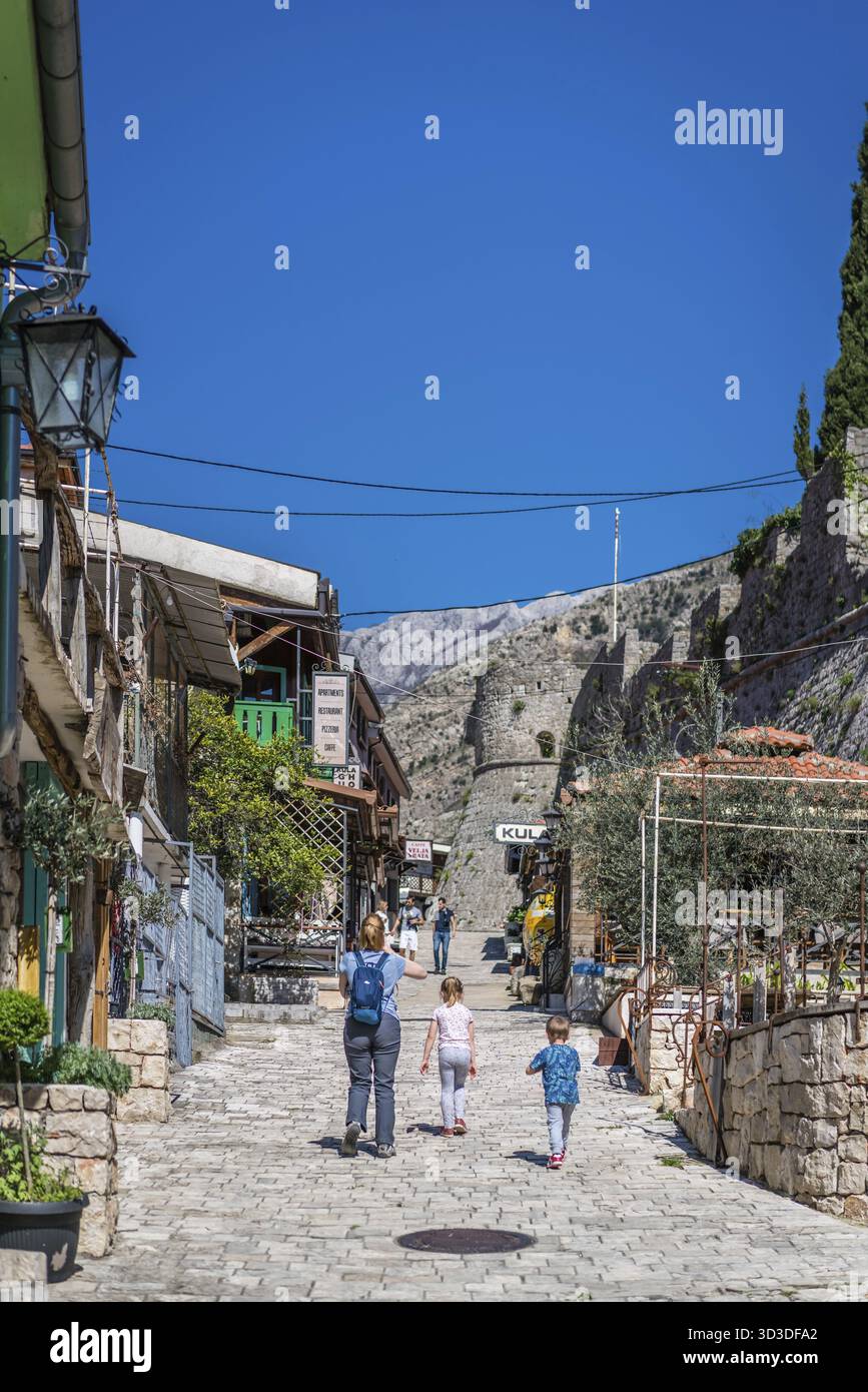 Stari Bar, Montenegro - Aprile 2018 : madre e bambini a piedi fino alla zona collinare strada piena di negozi di souvenir che conduce alla fortezza vecchia ruderi Foto Stock