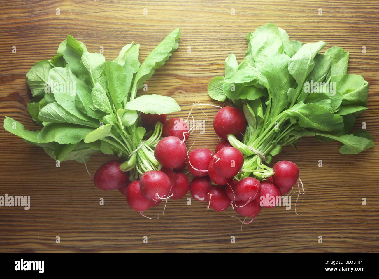 Due mazzetti di ravanelli su uno sfondo di legno Foto Stock