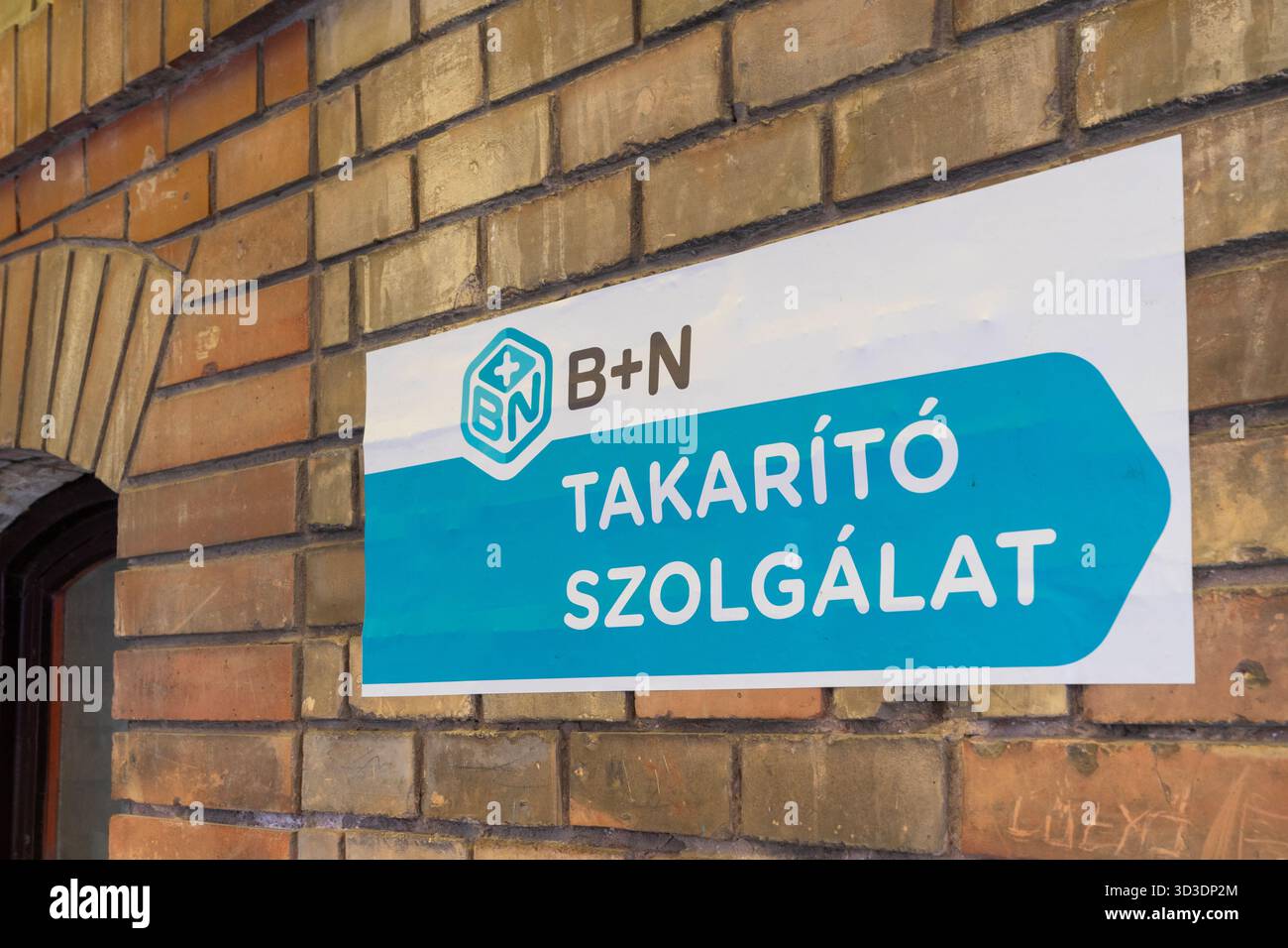 Cartello B+N Cleaning Service (servizio di pulizia B+N) sul muro di mattoni dell'ospedale San Giovanni di Budapest. Foto Stock