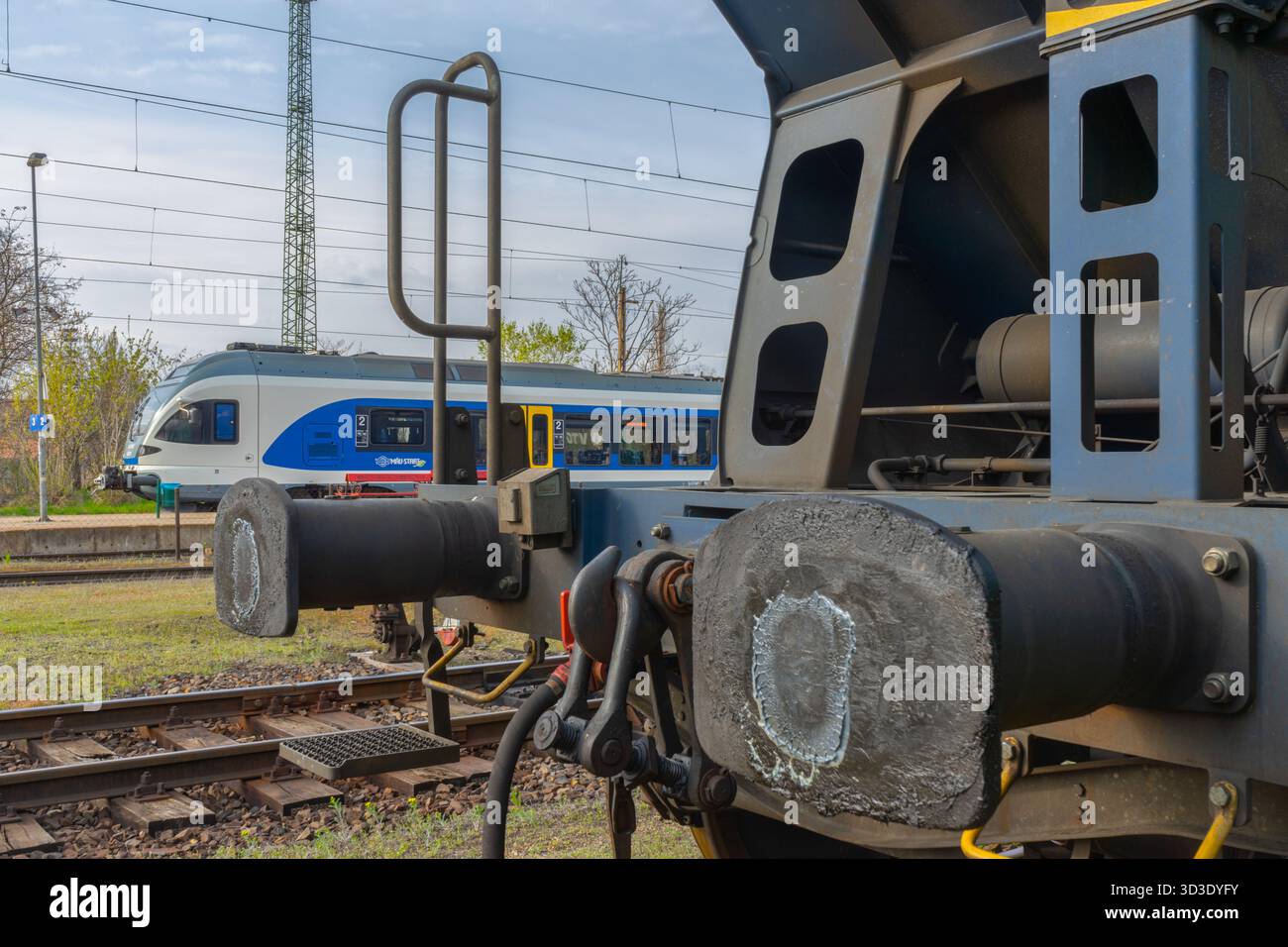 Primo piano di aggancio del carro merci presso lo scalo di smistamento di Budapest, che mostra i dettagli del sottotelaio e le infrastrutture del cantiere ferroviario. Foto Stock