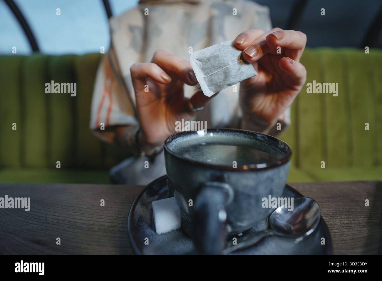 Donna della birra fresca di una tazza di tè con bustine di the in un cafe Foto Stock