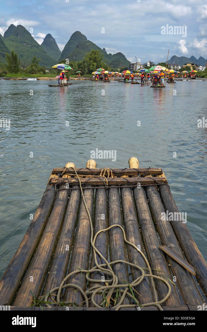 Yangshuo, Cina - Agosto 2019 : primo piano di zattera di bambù per il trasporto di turisti guidato da guide sul panoramico e bel fiume Yulong Foto Stock