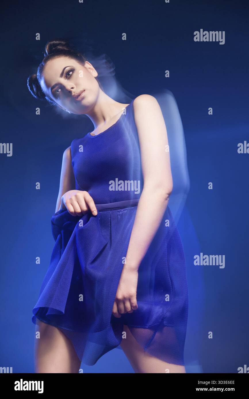 Ritratto di giovane e bella modello in posa vestito blu contro di sfondo blu.lunga esposizione Foto Stock