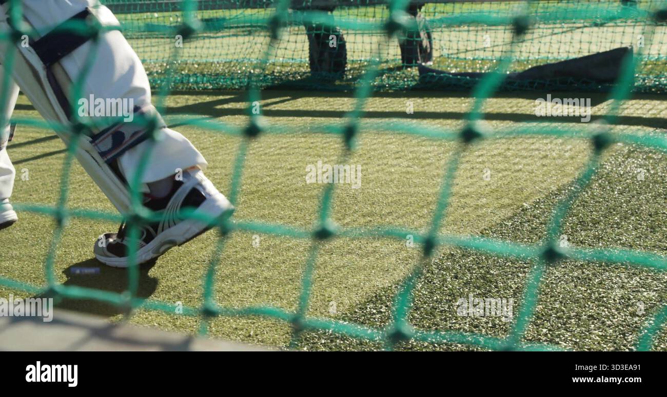 Muovere le gambe inferiori del battitore indossando i cuscinetti di battuta e i pantaloni bianchi per allenarsi in pratica rete, spazio per copiare Foto Stock