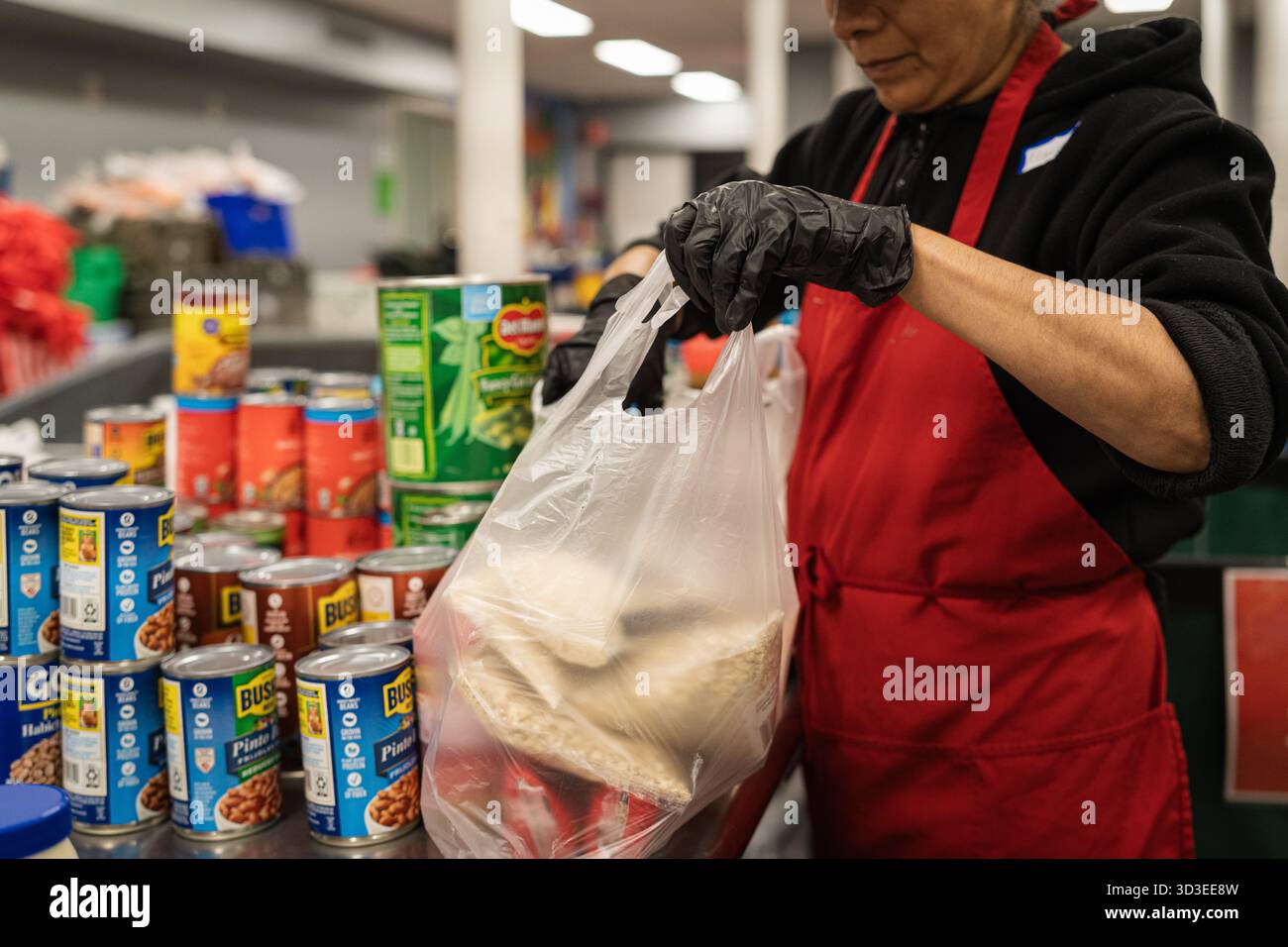 New York Ciy, Stati Uniti. 4 novembre 2025. La Community Kitchen, gestita dalla Food Bank di New York, sul Westside di Manhattan, a New York, offre pasti caldi e offre generi alimentari a circa 800 famiglie. Questo avviene dopo che il governo ha interrotto i benefici del programma supplementare di assistenza nutrizionale (SNAP) per oltre 42 milioni di persone. Recentemente il presidente Trump ha accettato di rilasciare parzialmente i fondi per il programma. 4 novembre 2025. (Foto di Steve Sanchez/Sipa USA). Crediti: SIPA USA/Alamy Live News Foto Stock