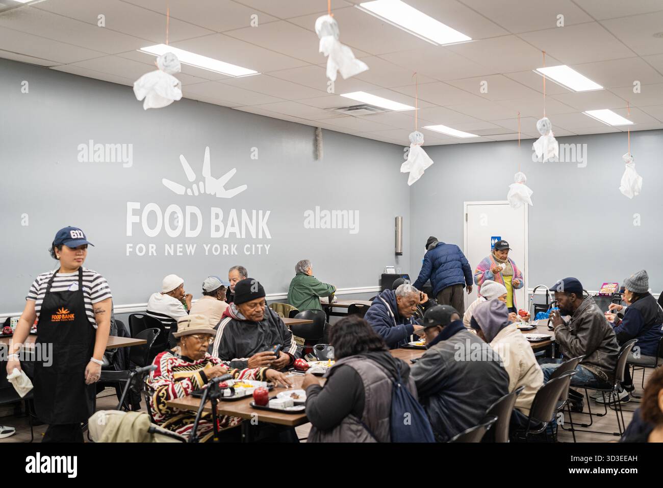 New York Ciy, Stati Uniti. 4 novembre 2025. La Community Kitchen, gestita dalla Food Bank di New York, sul Westside di Manhattan, a New York, offre pasti caldi e offre generi alimentari a circa 800 famiglie. Questo avviene dopo che il governo ha interrotto i benefici del programma supplementare di assistenza nutrizionale (SNAP) per oltre 42 milioni di persone. Recentemente il presidente Trump ha accettato di rilasciare parzialmente i fondi per il programma. 4 novembre 2025. (Foto di Steve Sanchez/Sipa USA). Crediti: SIPA USA/Alamy Live News Foto Stock
