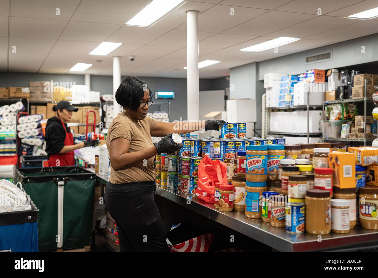 New York Ciy, Stati Uniti. 4 novembre 2025. La Community Kitchen, gestita dalla Food Bank di New York, sul Westside di Manhattan, a New York, offre pasti caldi e offre generi alimentari a circa 800 famiglie. Questo avviene dopo che il governo ha interrotto i benefici del programma supplementare di assistenza nutrizionale (SNAP) per oltre 42 milioni di persone. Recentemente il presidente Trump ha accettato di rilasciare parzialmente i fondi per il programma. 4 novembre 2025. (Foto di Steve Sanchez/Sipa USA). Crediti: SIPA USA/Alamy Live News Foto Stock