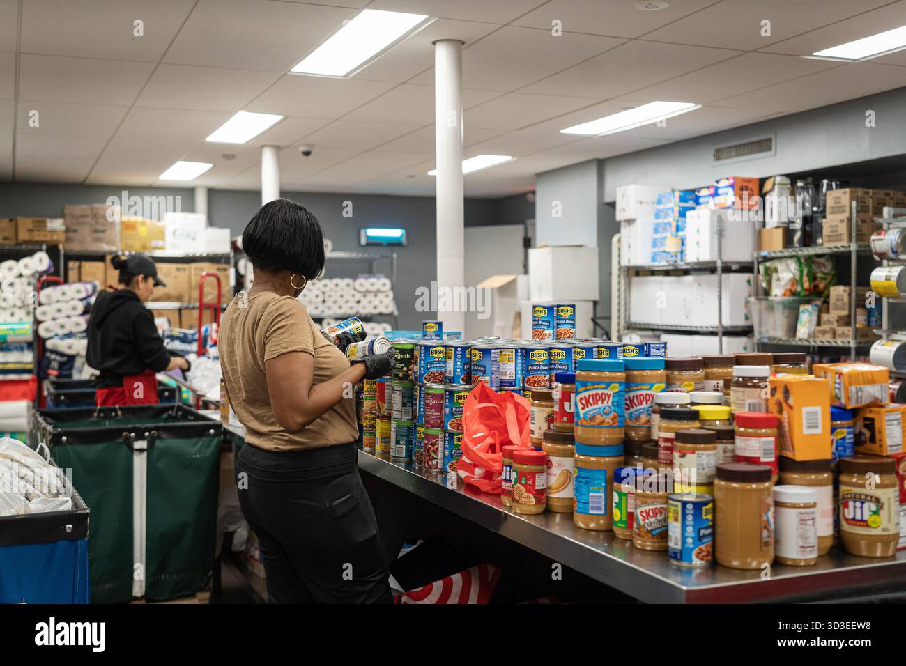 New York Ciy, Stati Uniti. 4 novembre 2025. La Community Kitchen, gestita dalla Food Bank di New York, sul Westside di Manhattan, a New York, offre pasti caldi e offre generi alimentari a circa 800 famiglie. Questo avviene dopo che il governo ha interrotto i benefici del programma supplementare di assistenza nutrizionale (SNAP) per oltre 42 milioni di persone. Recentemente il presidente Trump ha accettato di rilasciare parzialmente i fondi per il programma. 4 novembre 2025. (Foto di Steve Sanchez/Sipa USA). Crediti: SIPA USA/Alamy Live News Foto Stock