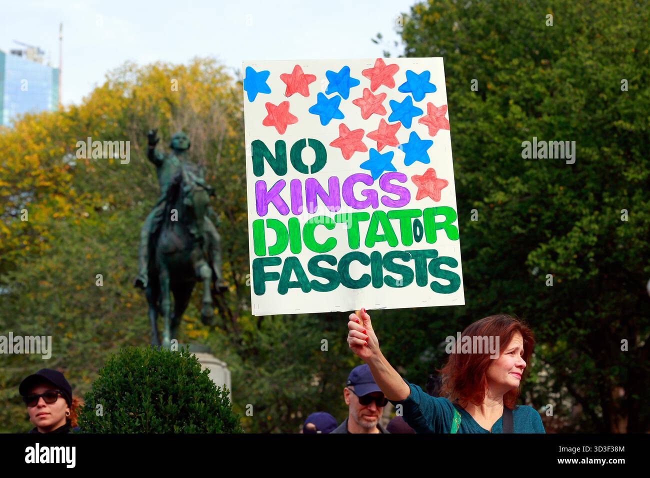 Una donna regge un cartello "No Kings, Dictator, Fascists" in occasione di una protesta contro l'amministrazione Trump, 18 ottobre 2025, New York City Foto Stock