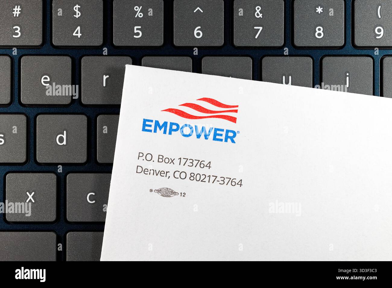 Una busta di Empower, una società di servizi finanziari, su una tastiera per computer Foto Stock