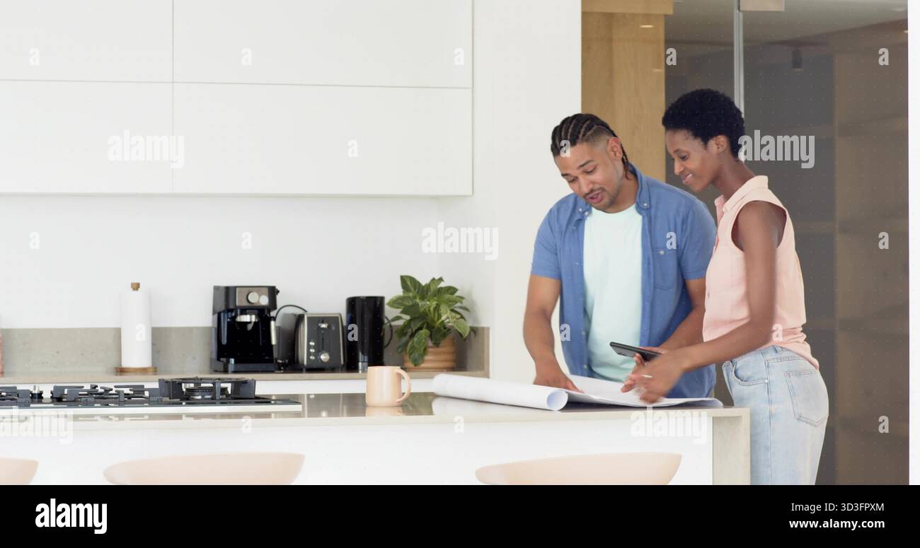 Revisione dei proprietari di case che stanno pianificando la ristrutturazione in una cucina moderna, con progetti e tablet Foto Stock