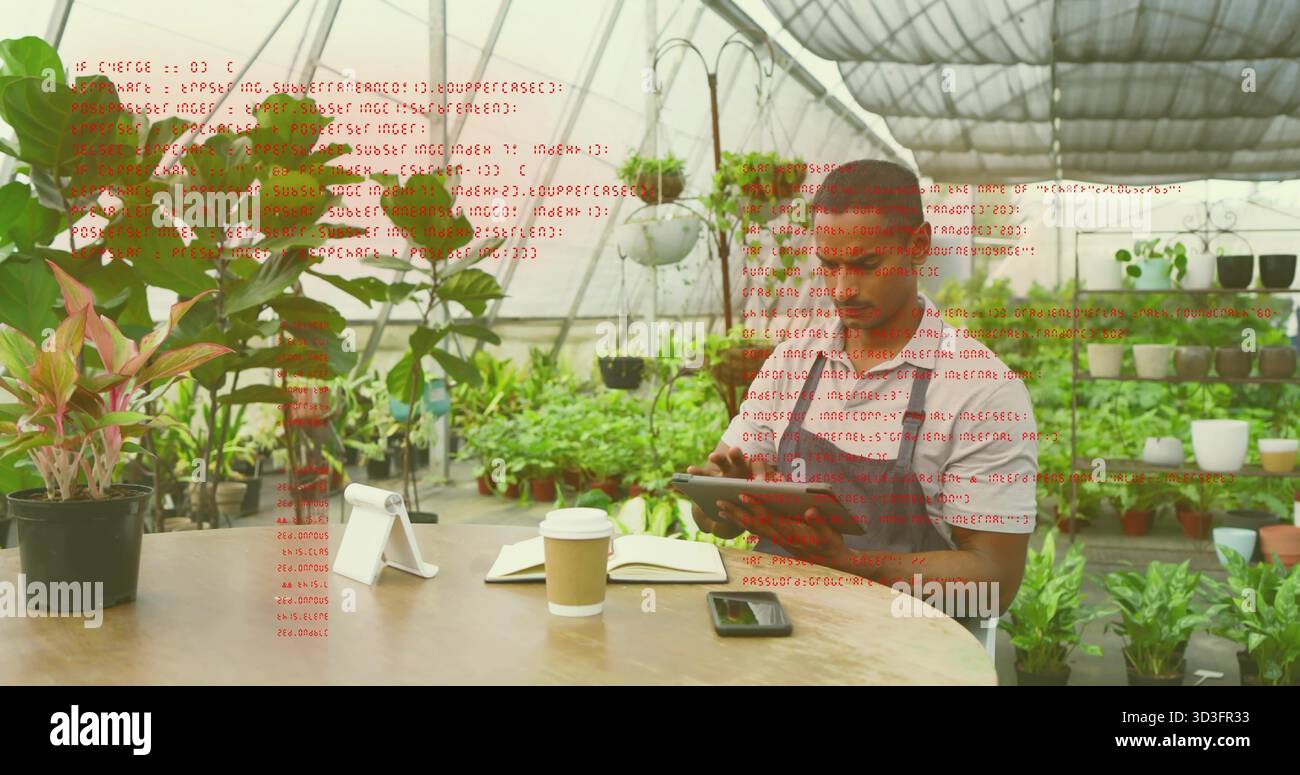 Lavoratore in serra in grembiule che esamina le note a tavola, con smartphone, tazza di caffè e piante in vaso Foto Stock