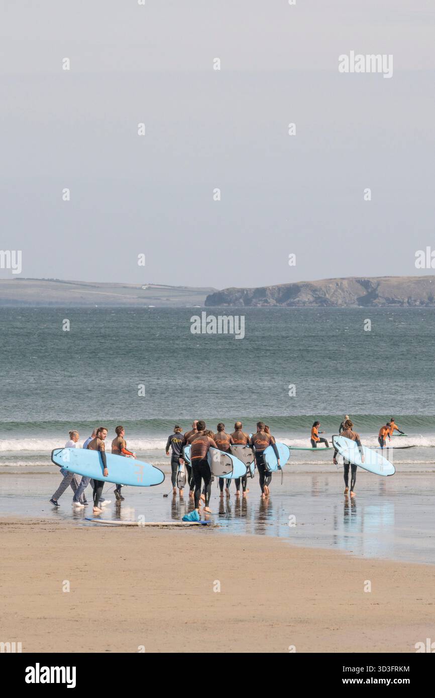 Un gruppo di vacanzieri in una lezione di surf con un istruttore della Cornish Wave Surf School presso Towan Beach a Newquay, in Cornovaglia, in Inghilterra Foto Stock