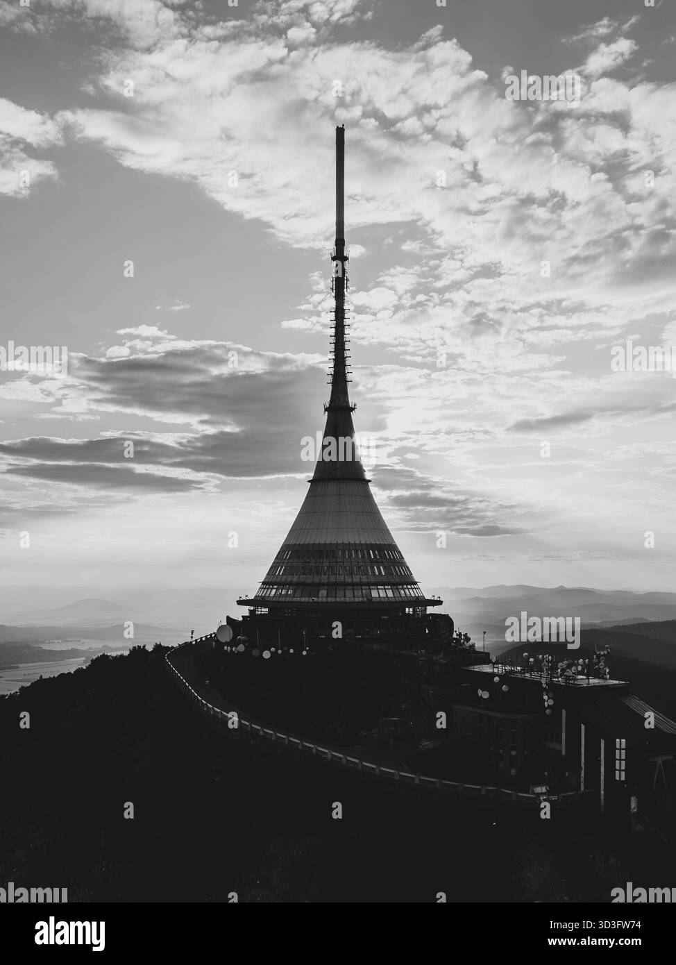 Il Jested Mountain Hotel si erge in alto sullo splendido cielo del tramonto a Liberec, mostrando la sua architettura moderna e la sua silhouette suggestiva mentre il sole tramonta all'orizzonte. Foto Stock