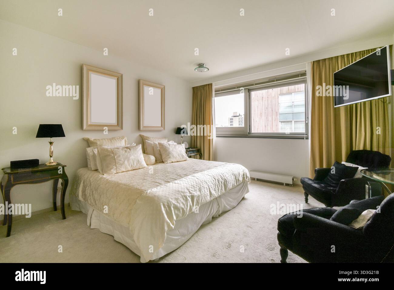 Camera moderna con arredi eleganti, biancheria da letto di lusso e grandi finestre che forniscono luce naturale. Il design e' intimo ma sofisticato, ideale Foto Stock