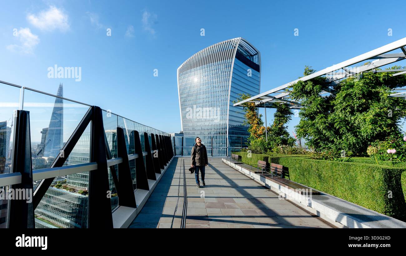 L'uomo ammira l'iconico skyline di Londra dal Garden al punto panoramico 120. Gli edifici Walkie-Talkie e Shard sono visibili in una giornata limpida e soleggiata Foto Stock