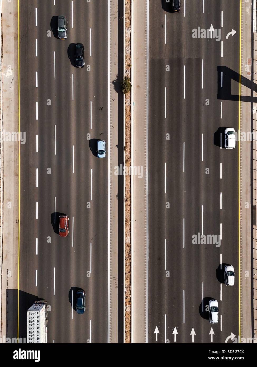 Vista aerea dei veicoli che attraversano l'autostrada a più corsie sotto il sole luminoso, gettando ombre sull'asfalto, Rosh HaAyin, North District, Israele. Foto Stock