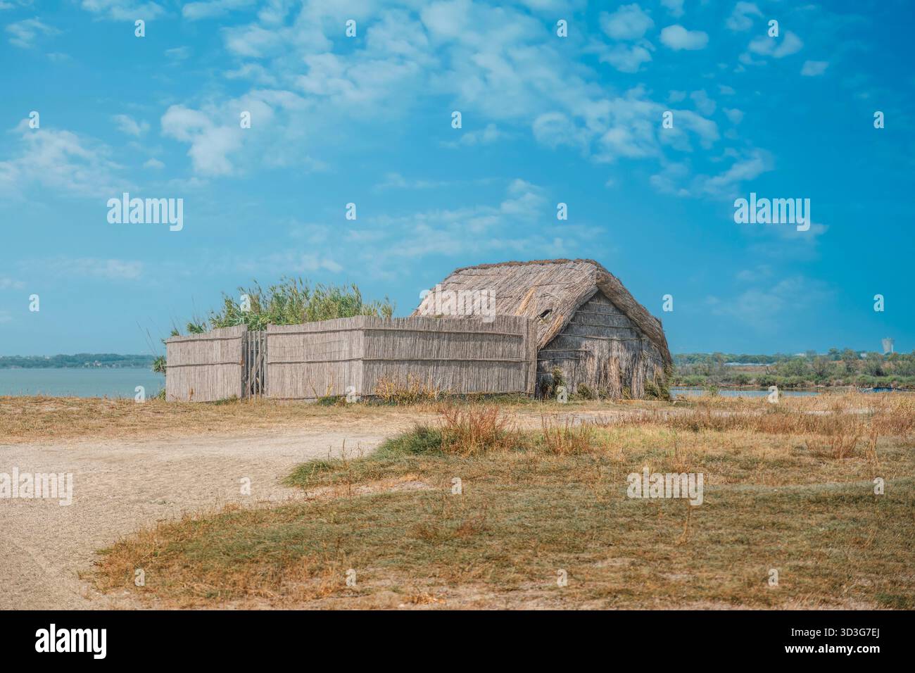 Capanna di paglia (cabane) sulla macchia secca vicino a un lago o a uno stagno, tipica architettura della regione della Camargue, Francia meridionale Foto Stock