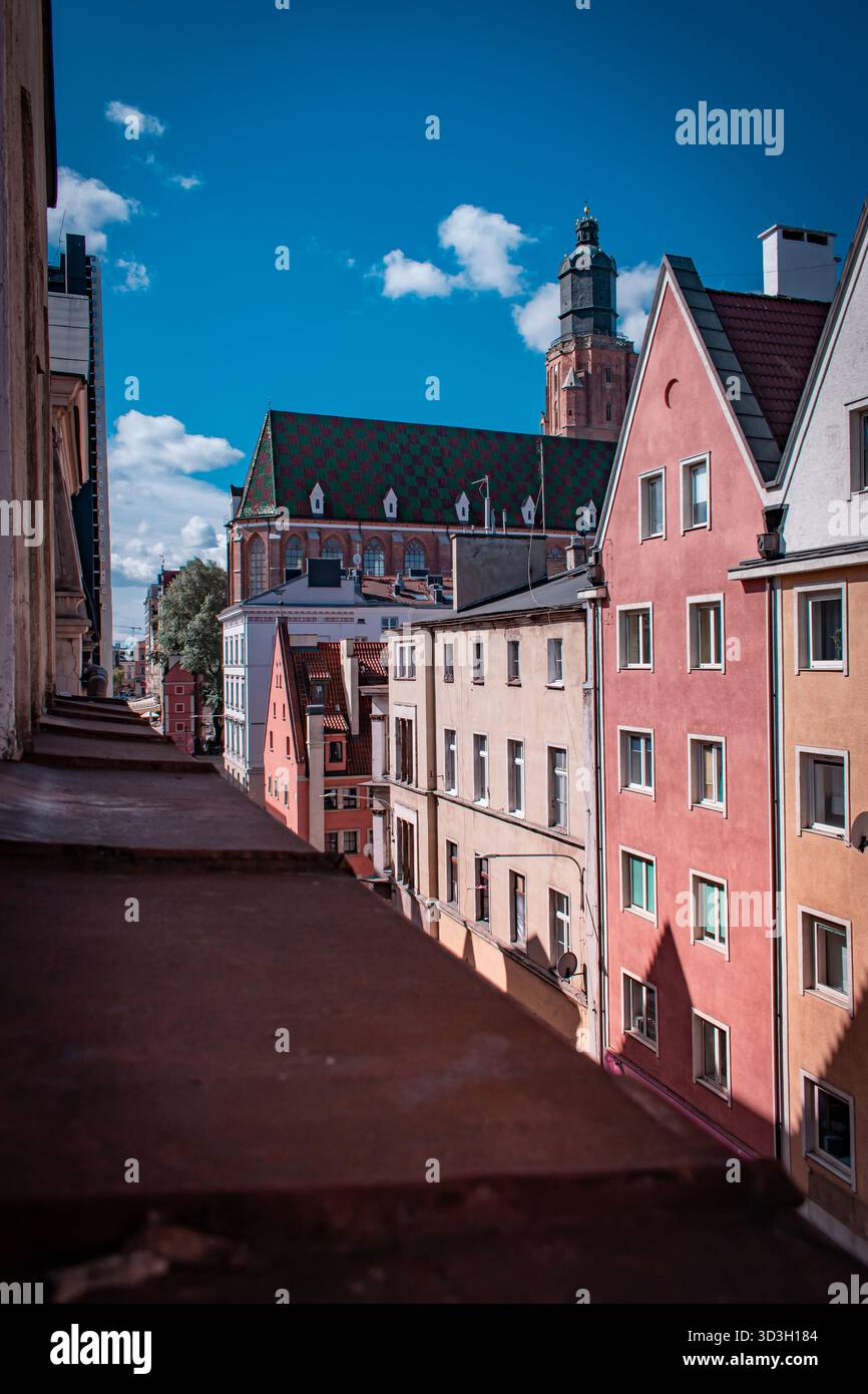 Una strada stretta a Breslavia, Polonia, illuminata dalla luce del sole. Lungo la strada ci sono case accoglienti e affascinanti. Foto Stock