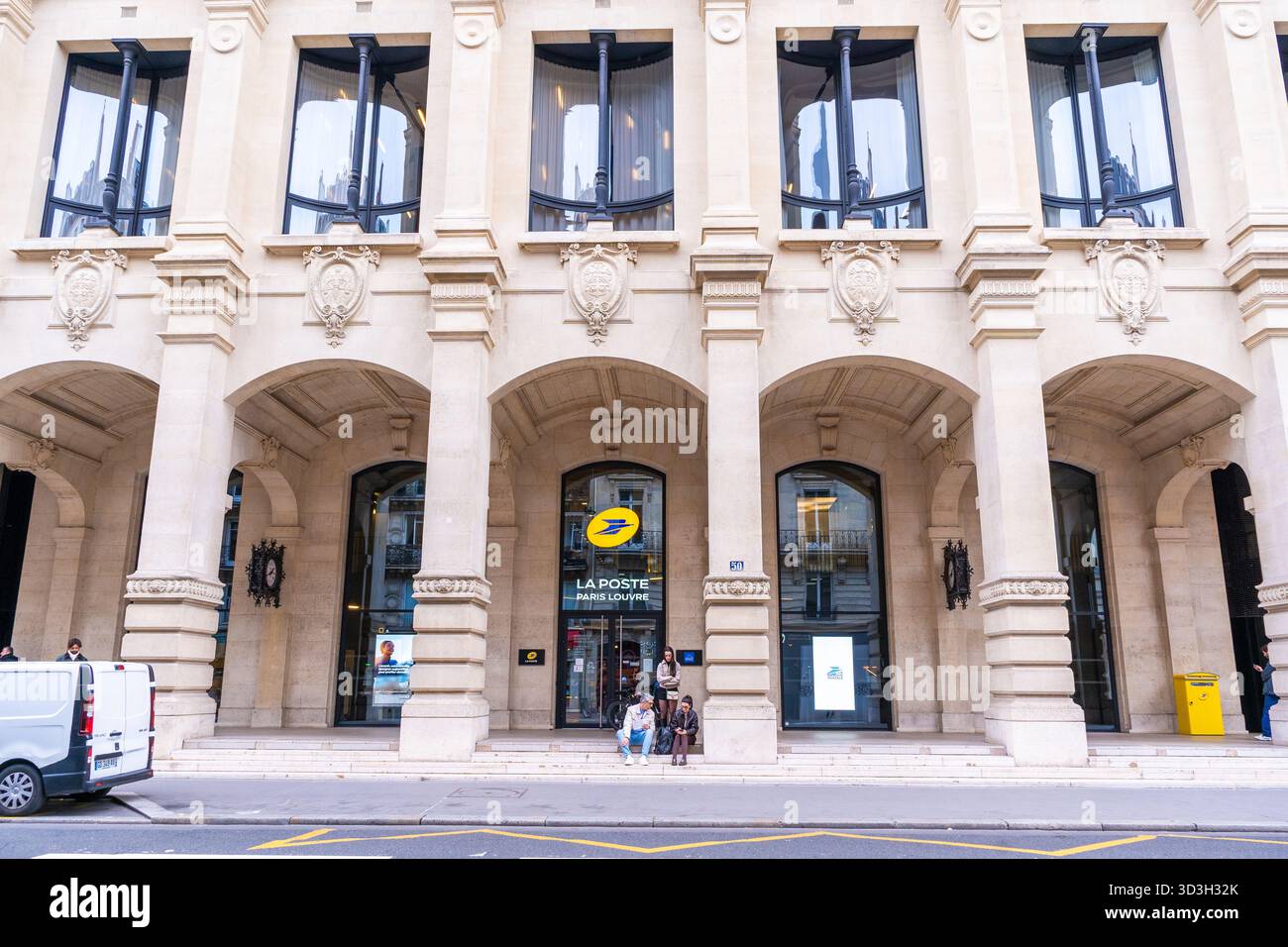 Parigi, Francia - 30 ottobre 2025: Ufficio postale d'ingresso con logo giallo LA POSTE Paris Louvre. Porta finestra. Strada esterna dell'edificio Foto Stock