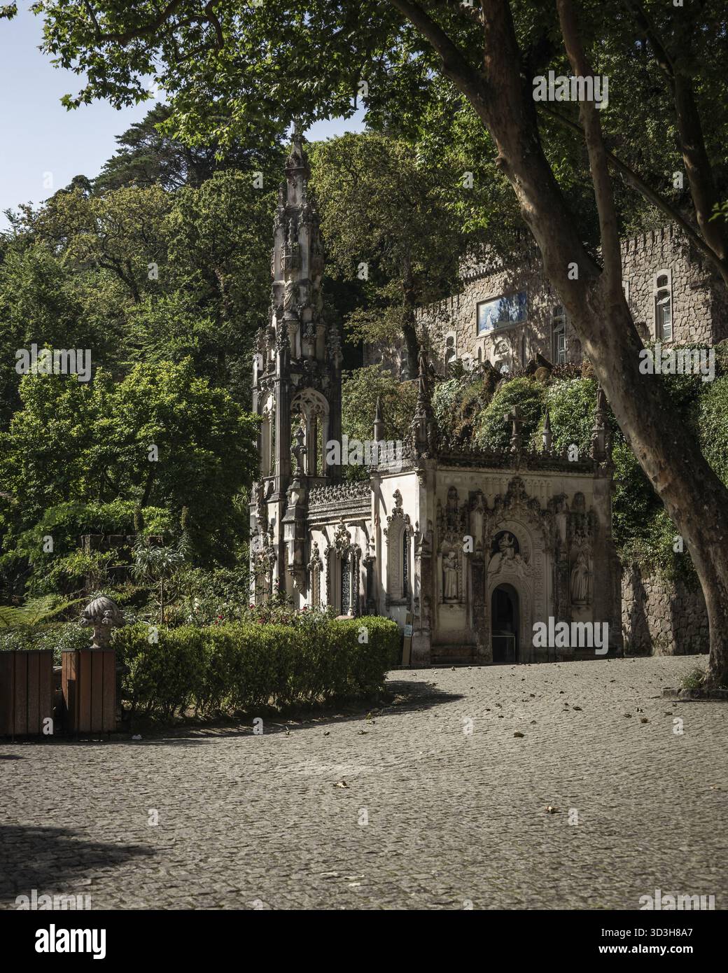 Vista di un edificio gotico con intricate pietre in mezzo a vegetazione lussureggiante, una tranquilla scena a Sintra, Lisbona, Portogallo, Sintra, Lisbona, Portogallo. Foto Stock
