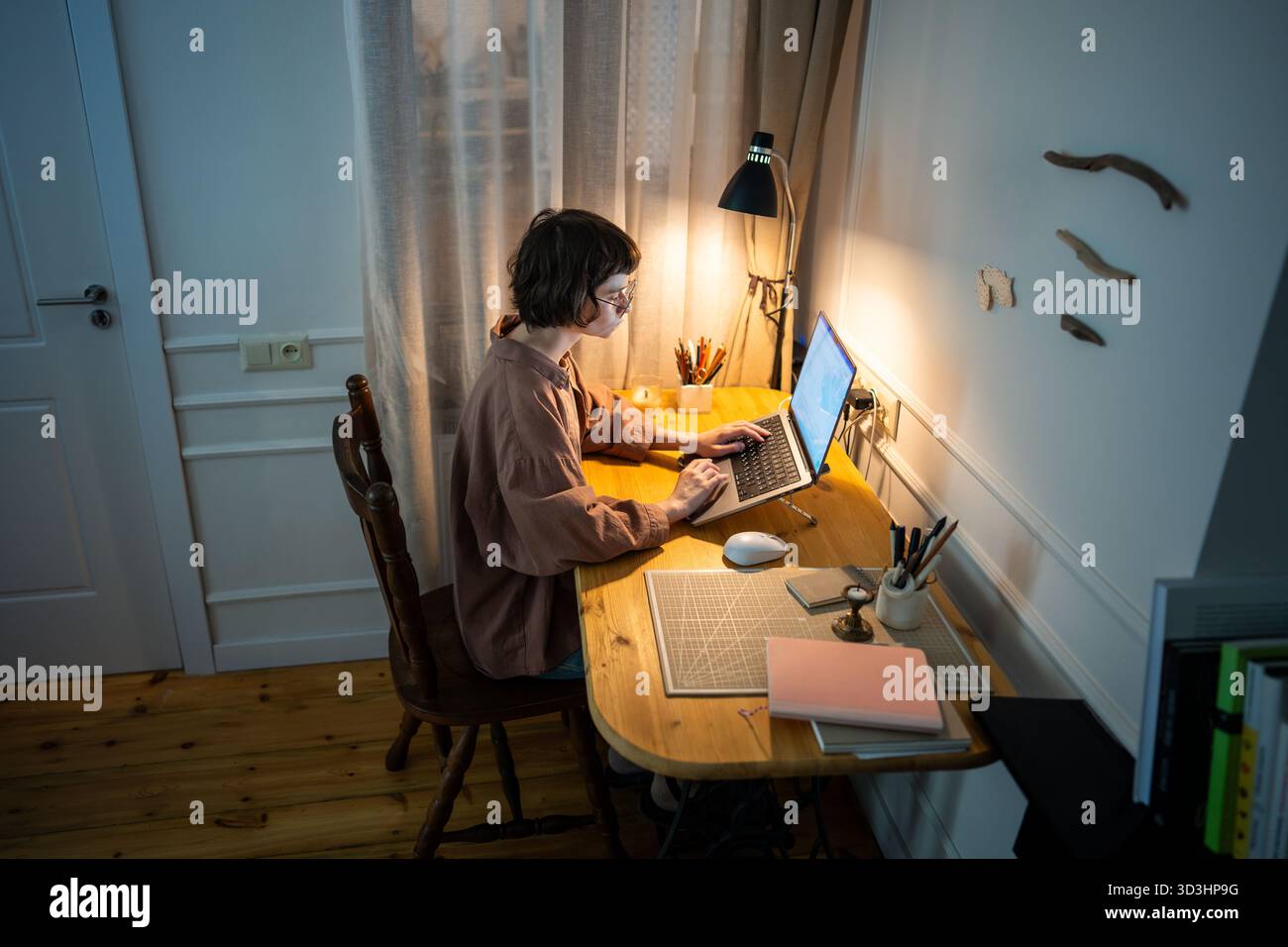 Donna concentrata e impegnata che lavora fino a tardi. Stanca e concentrata giovane donna che scrive un laptop a casa di notte Foto Stock