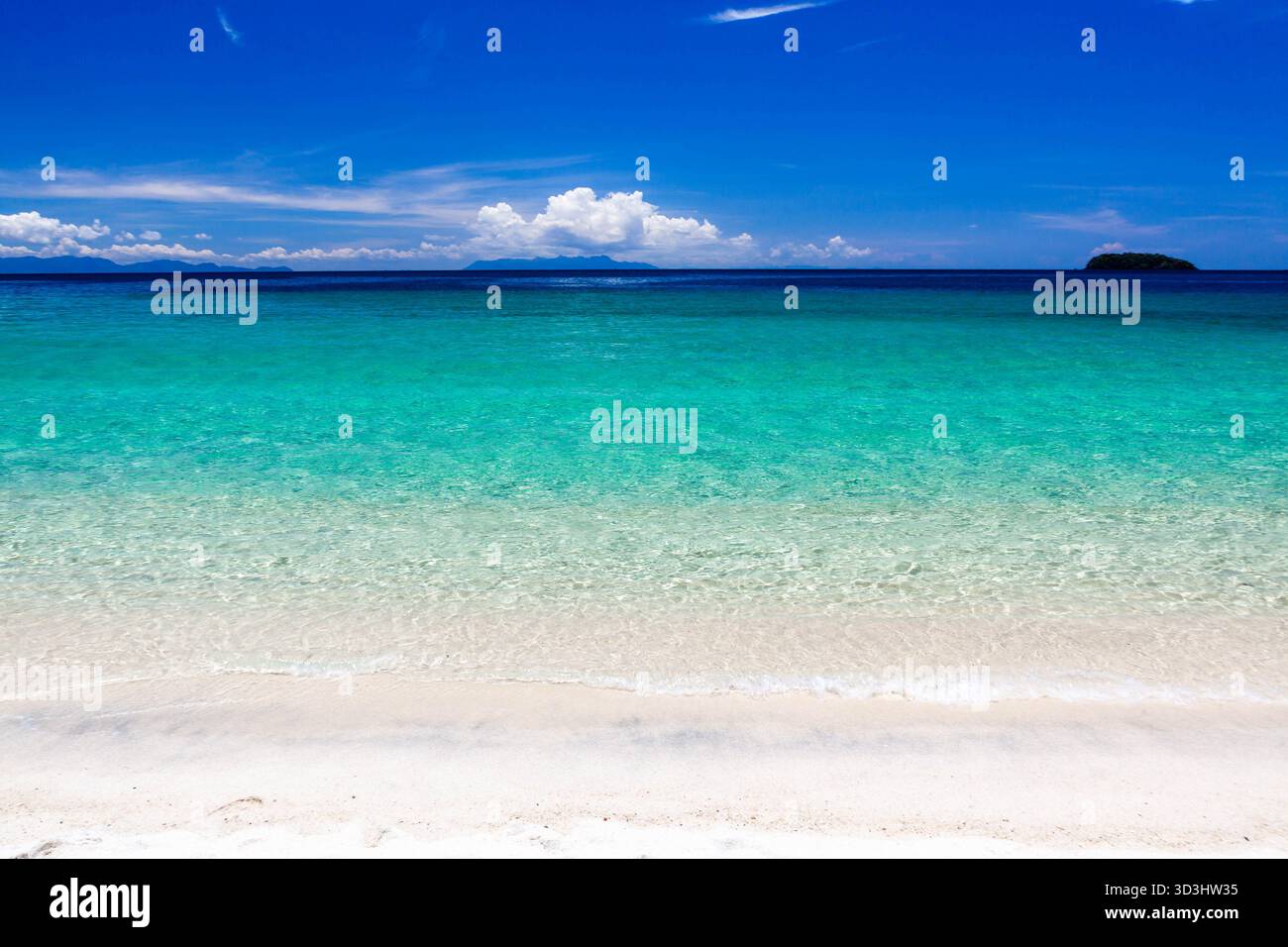 Il mare turchese cristallino delle Andamane incontra l'incontaminata spiaggia di sabbia sotto il cielo blu. Splendido paesaggio tropicale. Koh Adang, Thailandia. Foto Stock