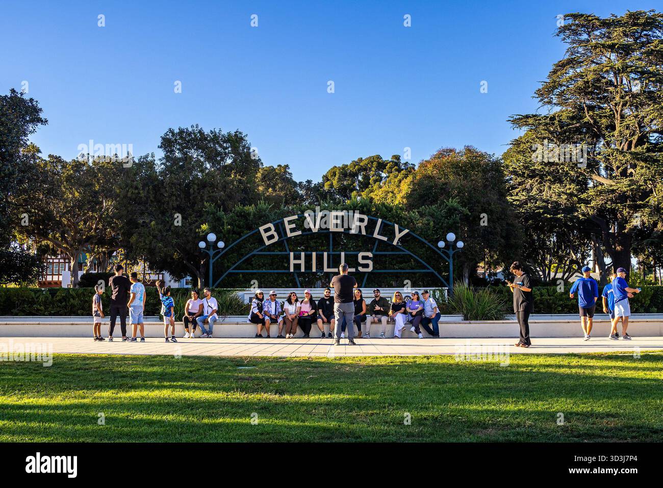 Gruppi di persone posano per delle foto di fronte all'iconico cartello di Beverly Hills a Beverly Hills, Los Angeles, California Foto Stock