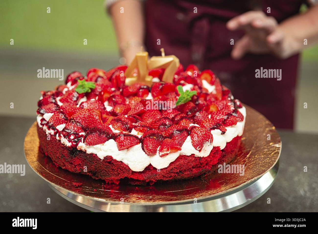 Cibo, torta alle fragole festiva con panna montata e frutti di bosco freschi, decorata con candele dorate per festeggiare il 47° compleanno Foto Stock