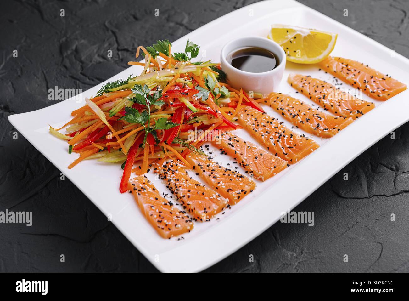 Cibo, fette di salmone con insalata di carote e peperoni e salsa di soia - cucina asiatica Foto Stock