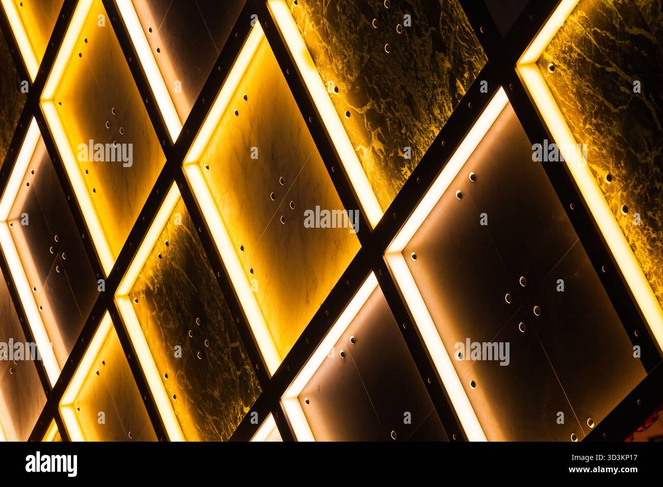 Pareti in piastrelle decorative con illuminazione interna in giallo e bianco con aree scure. Foto Stock