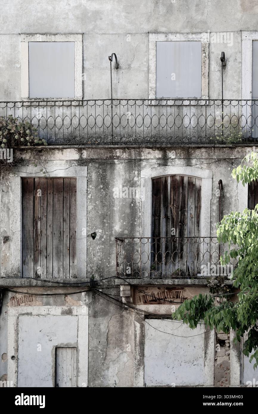 Finestre a bordo in una facciata di edificio in cemento a Lisbona, Portogallo Foto Stock
